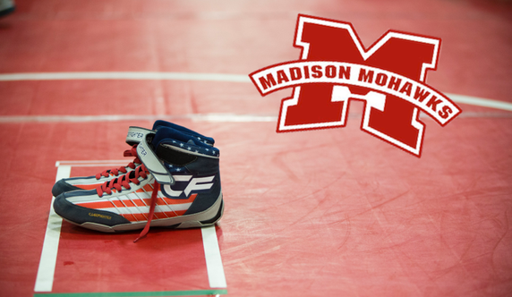 Shoes on wrestling mat with Madison Mohawks logo