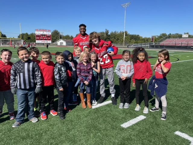 Elementary students with high school football players